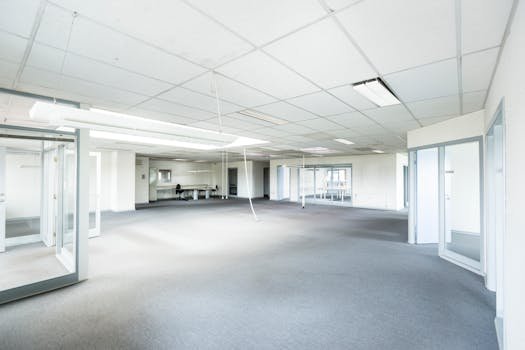 Home Bright empty office space featuring minimalist design and glass partitions.