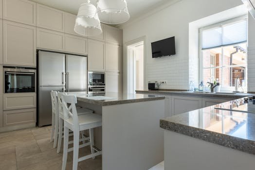 Home Spacious kitchen interior featuring granite countertops, stainless steel appliances, and a bright atmosphere.